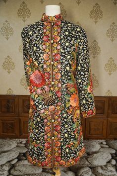 The "Nisbat-e-Nishat," or 'Relation to Joy,' is a hand aari embroidered jacket that showcases the joyful essence of a blooming garden. This exquisite piece, resplendent with floral vibrancy, is a single edition crafted with enduring dedication, mirroring the richness of Kashmir's horticultural wonders. * Singularly available, this jacket promises an exclusive experience of luxury. * Embroidered with care, each petal and leaf is a celebration of the season's bounty. * The dark backdrop highlights Traditional Nehru Jacket With Floral Print, Ceremonial Long-sleeve Outerwear With Floral Embroidery, Ceremonial Long Sleeve Outerwear With Floral Embroidery, Ceremonial Winter Outerwear With Intricate Embroidery, Traditional Floral Print Outerwear For Spring, Traditional Floral Print Spring Outerwear, Ceremonial Embroidered Winter Outerwear, Traditional Multicolor Floral Print Outerwear, Blooming Garden