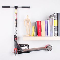 a scooter and books on a shelf in front of a wall mounted bookcase