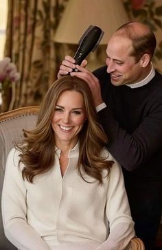 the man is cutting the woman's hair while she smiles and looks at her