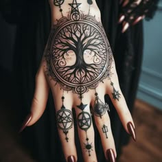 a woman's hand with tattoos on it and an image of a tree in the middle