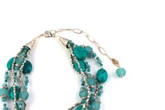 This beautiful necklace makes a great gift for the woman in your life who loves to wear jewelry—or just loves pretty things. This Statement Necklace features four strands of Turquoise, Sea glass, Amazonite, Silver beads and Swarovski© crystal. Secure lobster claw clasp on an adjustable chain. Perfect for layering, this necklace is a great addition to any jewelry collection. Elegant Turquoise Necklace With Faceted Beads, Elegant Beaded Turquoise Necklace, Elegant Turquoise Jewelry With Faceted Beads, Multi-strand Turquoise Gemstone Beads Necklace For Jewelry Making, Multi-strand Turquoise Necklace For Jewelry Making, Elegant Turquoise Necklace With Lobster Clasp, Turquoise Faceted Beads Costume Jewelry, Elegant Adjustable Turquoise Necklace With Faceted Beads, Elegant Multi-strand Turquoise Gemstone Necklace