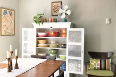 a dining room table and chairs with dishes on it