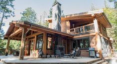 a large wooden house sitting on top of a lush green forest