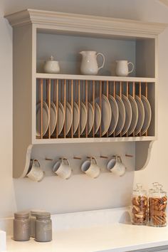 a shelf filled with plates and cups on top of a counter