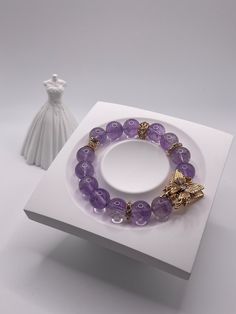 Size: 5.5-7.0inch 11mm This bracelet features natural amethyst beads, approximately 11cm, adorned with a gold-plated cubic zirconia butterfly. The design inspiration comes from the graceful elements of nature, evoking the light purple of lavender and the delicate flight of butterflies. This piece combines the mysterious allure of natural amethyst with the splendid elegance of gold-plated cubic zirconia, showcasing a blend of natural beauty, peace, and grace. Elegant Round Amethyst Crystal Bracelet, Amethyst 8mm Beads Jewelry Gift, Elegant Purple Round Crystal Bracelet, Elegant Round Purple Crystal Bracelet, Purple Amethyst Charm Bracelet Gift, Elegant Amethyst Gemstone Crystal Bracelet, Purple Amethyst Charm Bracelet For Gift, Elegant Amethyst Crystal Bracelet, Elegant Gold Amethyst Crystal Bracelet