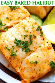 baked halved halibut on a plate with lemon wedges and parsley