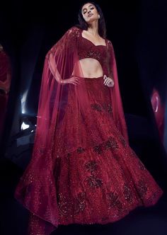 a woman in a red gown and cape