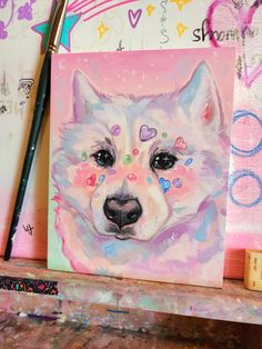 a painting of a white dog with hearts on it's face is shown next to a paintbrush