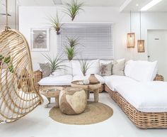 a living room with wicker furniture and plants