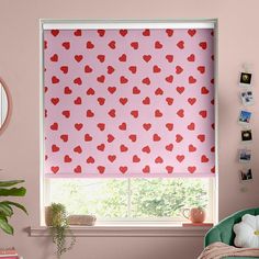 a room with pink walls and red hearts on the blind in the window sill