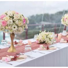 the table is set with pink and white flowers