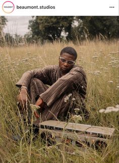 a man sitting in the middle of tall grass