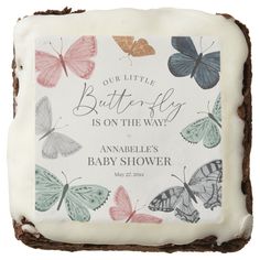 a square cake with butterflies on it and the words, our little butterfly is on the way