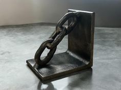 a metal object with a chain attached to it's sides on a table top