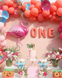 a flamingo themed birthday party with donuts, cake and balloons on the wall