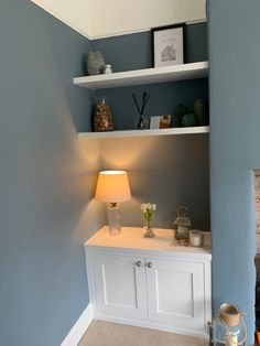 a room with blue walls and white shelves on either side of the wall is a fireplace