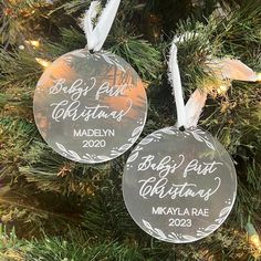 two personalized ornaments hanging from a christmas tree