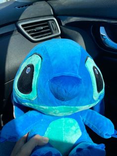 a blue stuffed animal sitting inside of a car