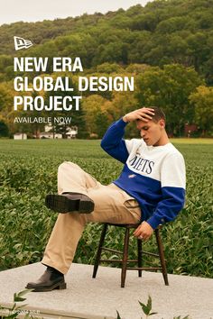 a young man sitting on top of a wooden chair in front of a lush green field