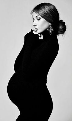 the pregnant woman is posing for a black and white photo with her hands on her hips