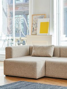 a couch sitting on top of a hard wood floor next to a large glass window