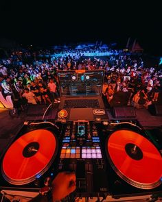 a dj mixing music in front of a large crowd