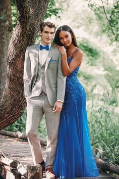 a man and woman standing next to each other near a tree