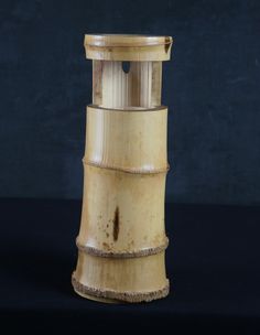 a tall wooden object sitting on top of a black surface