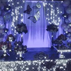 an image of a party setting with balloons and butterflies on the wall at night time