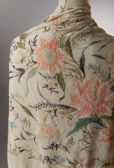 the back of a dress with flowers and leaves on it's side, in pastel colors