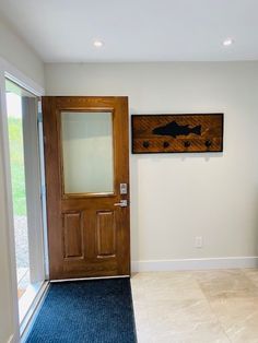 an empty room with blue carpet and a wooden door