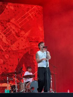 a man standing on top of a stage holding a microphone