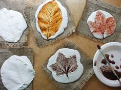 four leaf shaped cookies sitting on top of burlocks covered in icing and paint