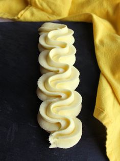 a yellow cloth and some food on a black counter top with a fork in it