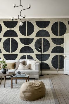 a living room with black and white circles on the wall next to a coffee table