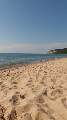 the beach is covered in sand and blue skies are visible behind it on a sunny day