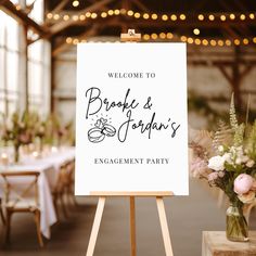 a welcome sign sitting on top of a wooden easel in front of a table