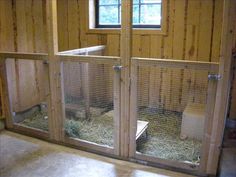 the inside of a coop with hay in it and two doors open to let in some light