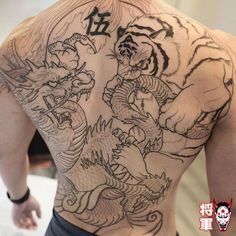 a man with a tiger and dragon tattoo on his back