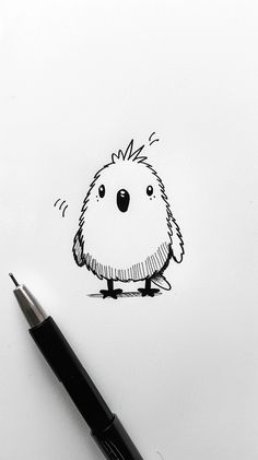 a drawing of a small bird on a piece of paper with a pen next to it