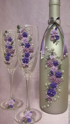 two wine glasses and a bottle decorated with flowers