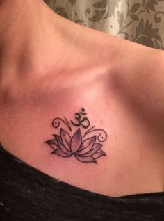 a woman's chest with a lotus tattoo on the left side of her stomach