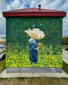 a painting on the side of a building with a man holding a flower in his hand