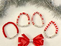 three red and white beaded bracelets with a bow