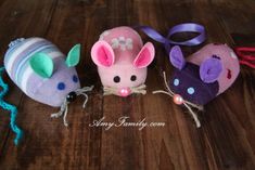 three stuffed mice are sitting on a wooden table