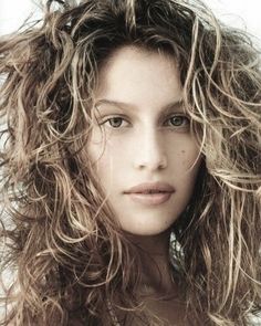 a beautiful young woman with long curly hair