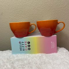 two orange cups sitting on top of a box