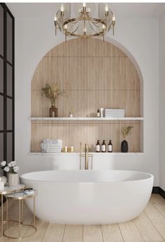 a large white bath tub sitting in a bathroom next to a wooden shelf with bottles on it