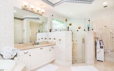 a large bathroom with a walk in shower next to a sink