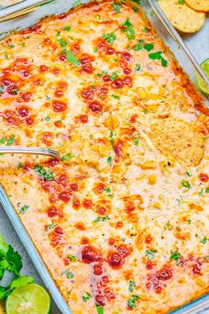 a casserole dish with cheese, tomatoes and cilantro on the side